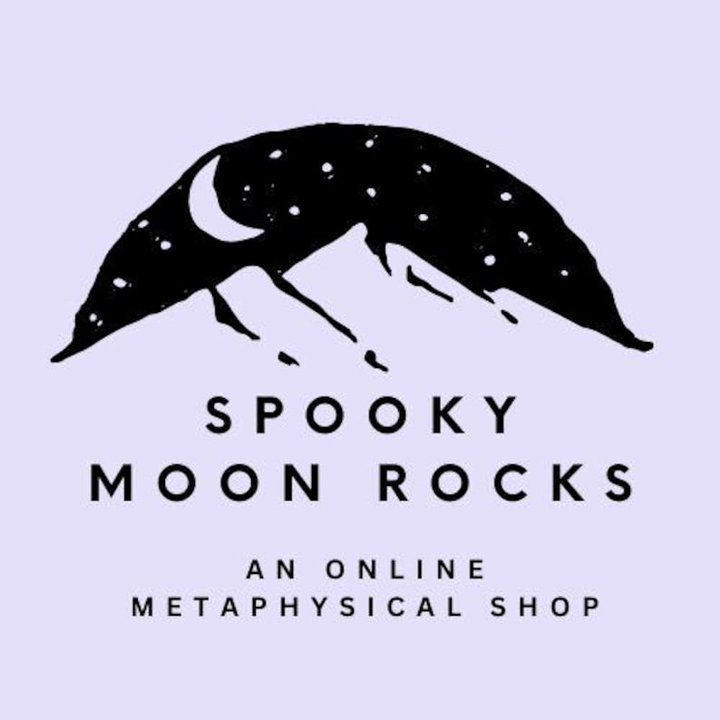 K&ouml;nnte beinhalten: Ein Logo mit einer schwarzen Bergketten-Silhouette unter einem Sternenhimmel und einem Halbmond. Der Text "SPOOKY MOON ROCKS" ist darunter zentriert, mit "AN ONLINE METAPHYSICAL SHOP" darunter, alles auf einem lavendelfarbenen Hintergrund.