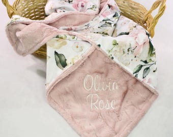 May include: A pink and white floral baby blanket with a soft, plush backing. The blanket is personalized with the name "Olivia Rose" embroidered in white.