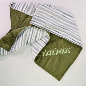 May include: A green and white striped baby blanket with the name "Maximus" embroidered on it.