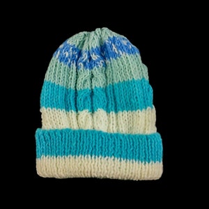 Hand knitted baby Aran cable hat in blue and cream striped yarn to fit  15 inch head 3 months on a black background