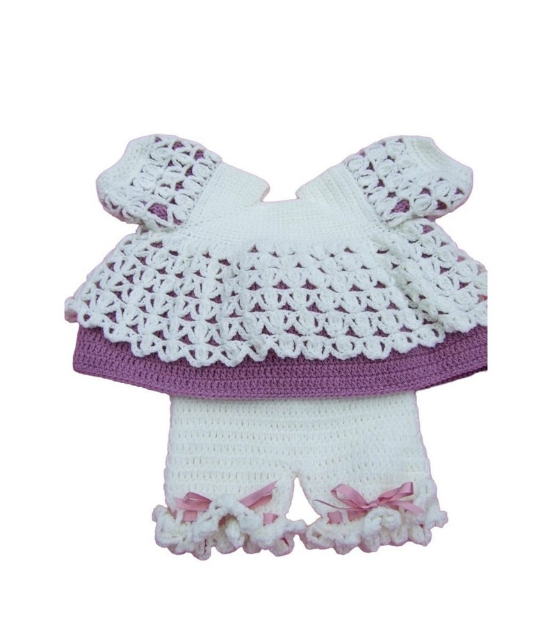 Hand crocheted baby angel top and shorts in mauve and cream on a white background