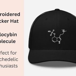 Op de afbeelding: Zwarte truckercap met een wit geborduurd beeld van het psilocybine-molecuul. Het molecuul is gelabeld met de chemische formule.
