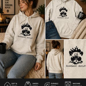 Könnte beinhalten: Hellgrauer Kapuzenpullover mit einem schwarzen Grafikmotiv einer Katze mit Krone und Sonnenbrille und dem Text "Goddamit, donut!". Der Hoodie hat eine Vordertasche und eine Kapuze mit Kordelzug.
