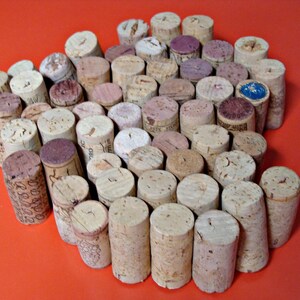 May include: A close-up of a cork trivet made from wine corks. The corks are arranged in a circular pattern with a few corks in the center. The trivet is a light brown color and has a natural, rustic look.