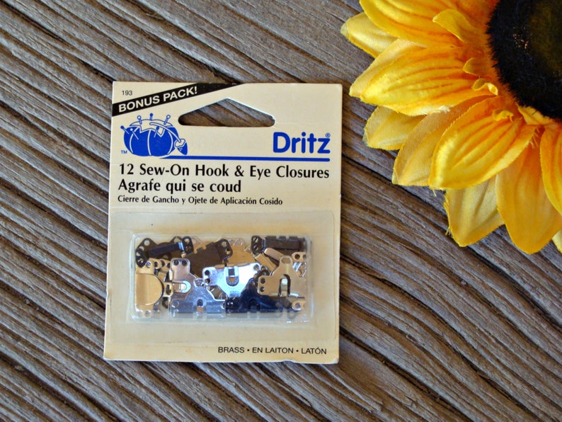 May include: A package of 12 sew-on hook and eye closures in brass. The package is labeled "Dritz" and says "Bonus Pack!"