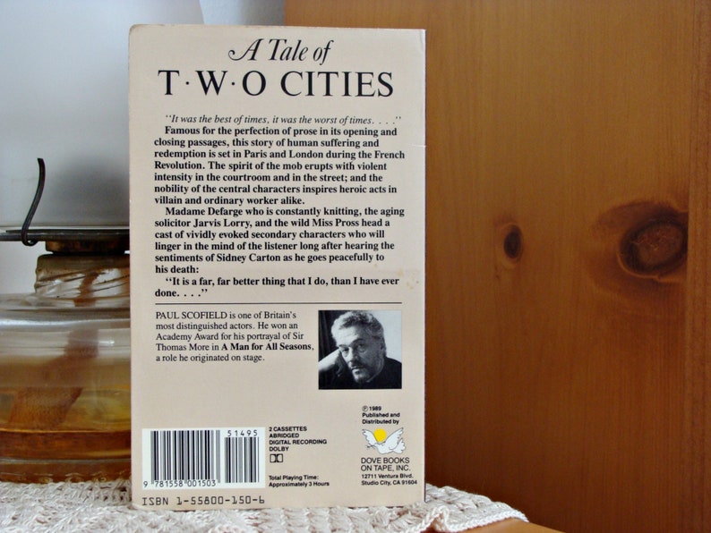 May include: A Tale of Two Cities audiobook cassette case. The cover displays the title in a classic font. The back includes a synopsis, author details, and a photo of Paul Scofield. The case is a vintage item.