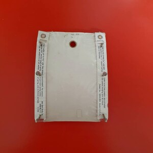 May include: White plastic plate hanger with a spring adjustment for plates up to 7 1/4 inches. The hanger has a hole in the center and a small white label with instructions for use. Patent No. 2,826,384 Made in U.S.A.
