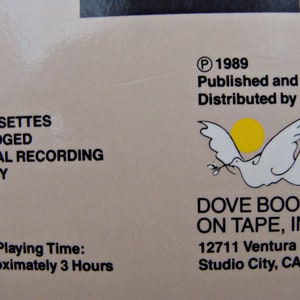 May include: A close-up of a beige cassette tape case with text and a dove logo. The text includes "2 Cassettes," "Digital Recording," and "Approximately 3 Hours." The dove logo features a white dove with a yellow sun.