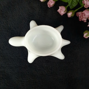 May include: White ceramic turtle shaped dish with a smooth, rounded interior. The dish is perfect for holding small items or serving snacks.