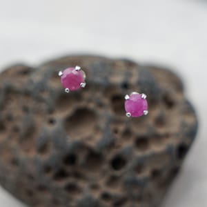 Może przedstawiać: Para srebrnych kolczyków z małymi, okrągłymi, różowymi kamieniami szlachetnymi.
