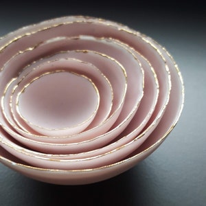 Set of 7 stoneware fine bone china nesting bowls in dusty pink and white with various finishes. Gold