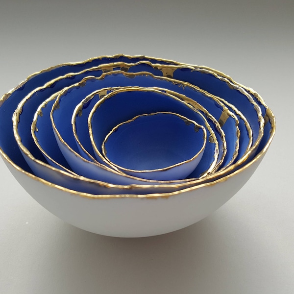 Set van 7 kleine nestkommen van fijn porselein van steengoed in blauw en wit met echt gouden afwerking.