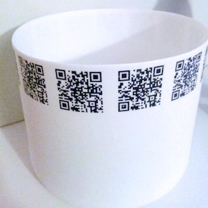 May include: A white ceramic bowl with four black and white QR codes printed around the rim.