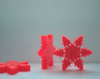 Orange snowflakes laser cut and engraved from thick acrylic in two limited edition designs