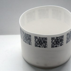 May include: White ceramic bowl with a black and white QR code design around the rim.