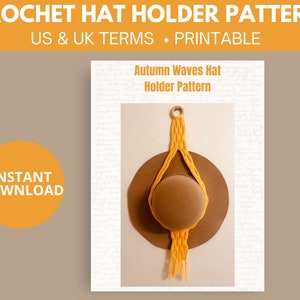 Peut inclure: Un modèle de crochet imprimable pour un porte-chapeau Autumn Waves. Le modèle comprend des instructions pour les termes de crochet américains et britanniques. L'image montre un chapeau marron suspendu à un porte-chapeau en crochet jaune.