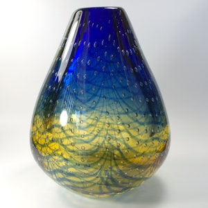 May include: A blue and yellow glass vase with a textured surface and a teardrop shape.