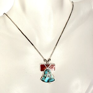 Peut inclure: Un collier en argent avec un pendentif en forme de cloche en turquoise et en pierre rouge.
