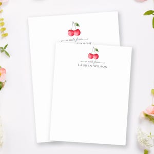 May include: Two white note cards with a cherry illustration and the text "a note from" followed by a name. The cherry illustration is in watercolor style with red cherries and green leaves.