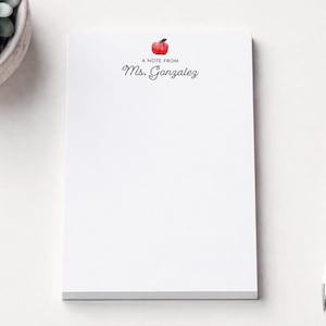 a blank white notepad with a personalized note from "Mrs. Gázquez" printed on it, along with a pen and a small potted succulent plant.