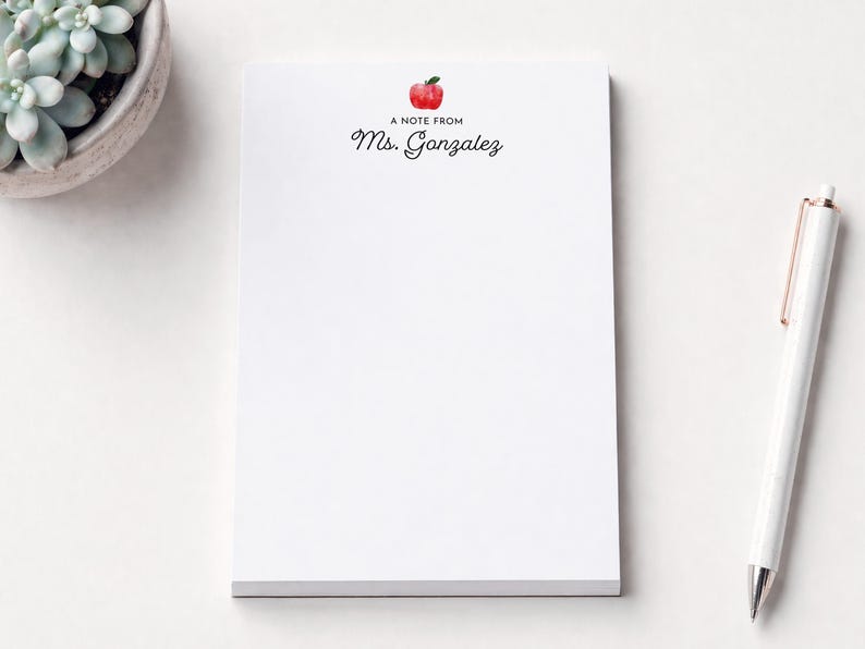 a blank white notepad with a personalized note from "Mrs. Gázquez" printed on it, along with a pen and a small potted succulent plant.