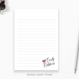 May include: Pink lined notepad with the text "Emily Robbins" and a pink heart.