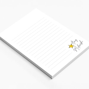 May include: A white notepad with lined paper and a yellow star with the name "Amy Milewski" written in black cursive.