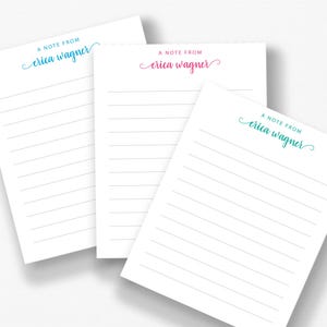 three blank lined notepads with the name 'Ella Wagner' printed on them.