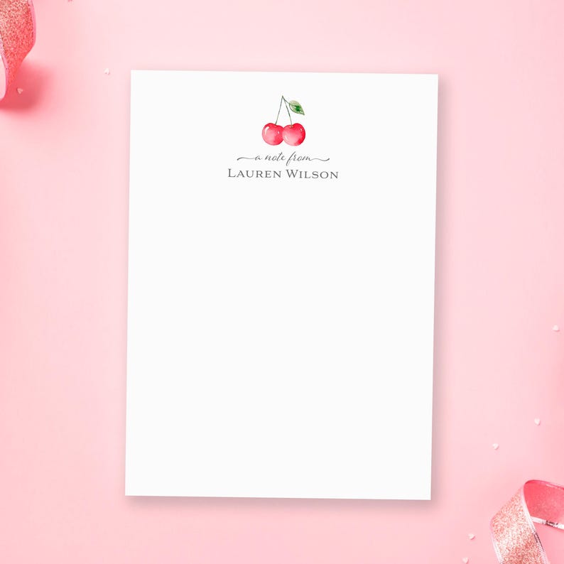 May include: White notepad with a cherry illustration and the text "a note from LAUREN WILSON".