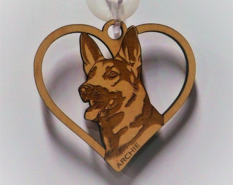 May include: A wooden heart-shaped ornament with a laser-engraved image of a German Shepherd dog. The dog's name, "ARCHIE", is engraved below the image.