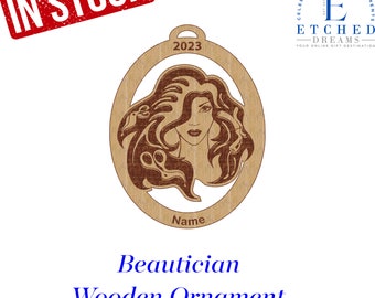 May include: A wooden ornament shaped like a circle with a brown background and a cutout of a woman with long hair. The ornament is engraved with the text "2023" and "Name". The text "Beautician Wooden Ornament" is below the ornament.