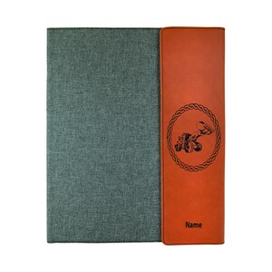 May include: A brown leatherette folder with a gray fabric cover. The folder has a circular design with a tractor and the text "Name" on the front.