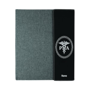 May include: A gray and black binder with a medical symbol and the letters "PA" in a circle. The binder has a stitched edge and the words "Name" are printed on the front.