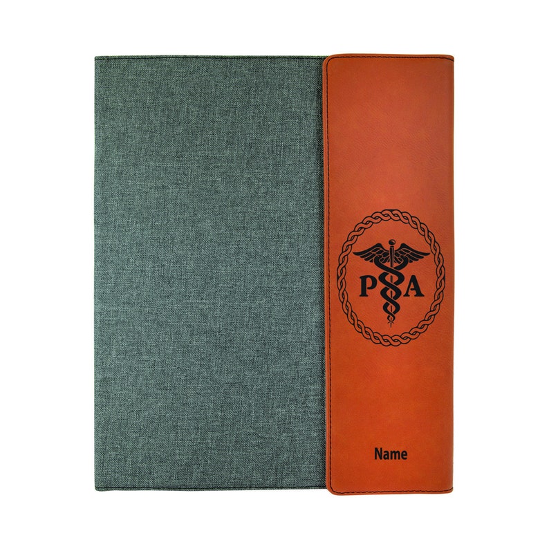 May include: A brown leatherette folder with a gray fabric cover. The folder has a pocket on the right side with a medical symbol and the letters "PA" engraved on it. The text "Name" is also engraved on the pocket.