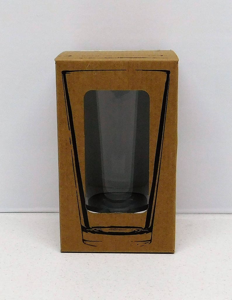 May include: A brown cardboard box with a clear window showing a glass pint glass.