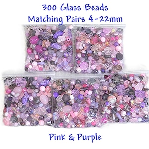 May include: Five clear plastic bags filled with 300 assorted glass beads in various shades of pink and purple. The beads come in matching pairs ranging from 4-22mm in size. Text on the image reads: 300 Glass Beads, Matching Pairs 4-22mm, Pink & Purple.