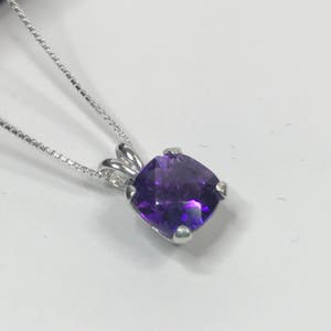 May include: A silver chain necklace with a purple amethyst gemstone pendant.