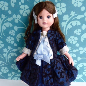 May include: A porcelain doll with brown hair, blue eyes, and a blue and black dress. The doll is wearing white tights and black shoes. The doll is standing on a blue and white patterned background.