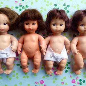 Your choice from 8x AMANDA JANE BABY Dolls, each with thick hair in various styles, and each will come wearing a traditional nappy/diaper!