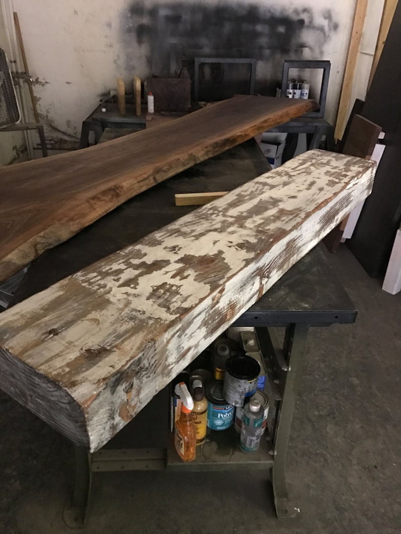 May include: A weathered wooden shelf with a whitewashed finish. The shelf is sitting on a metal workbench with various paint cans and cleaning supplies.