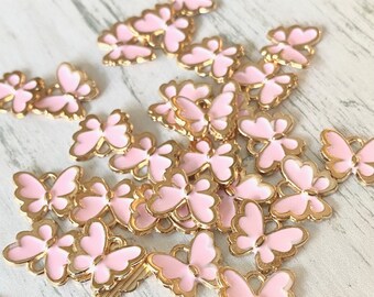 May include: A scattering of pink and gold butterfly charms. The butterflies have a delicate, detailed design and are perfect for adding a touch of whimsy to jewelry or crafts.
