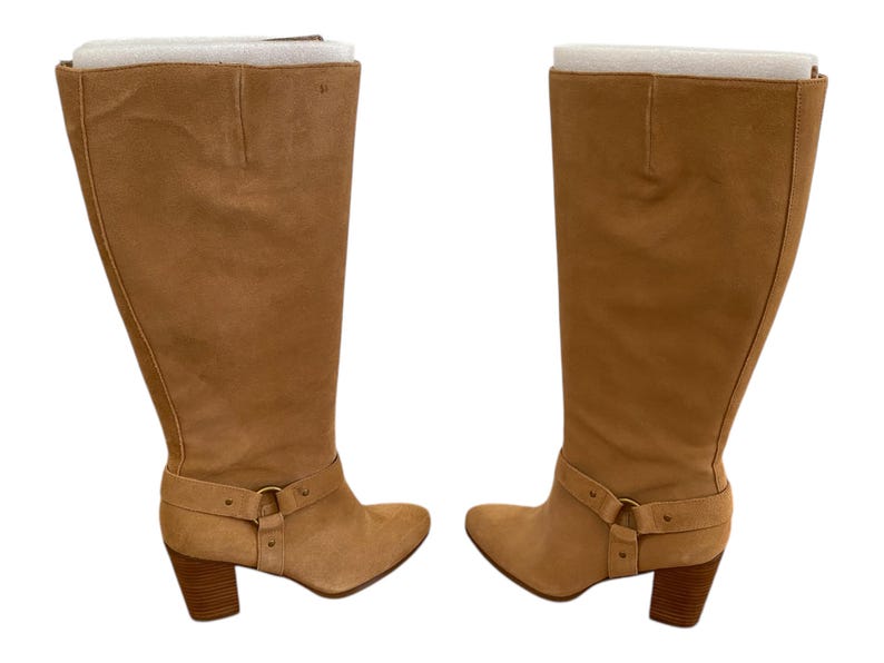 Puede incluir: Un par de botas de ante beige de ca&ntilde;a alta con tac&oacute;n de bloque y detalle de hebilla en el tobillo.