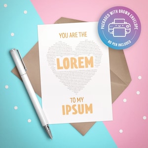 Puede incluir: Una tarjeta blanca con el texto "You are the Lorem to my Ipsum" en forma de corazón. La tarjeta está empaquetada con un sobre marrón y una pegatina que dice "Empaquetado con sobre marrón, no se incluye bolígrafo".