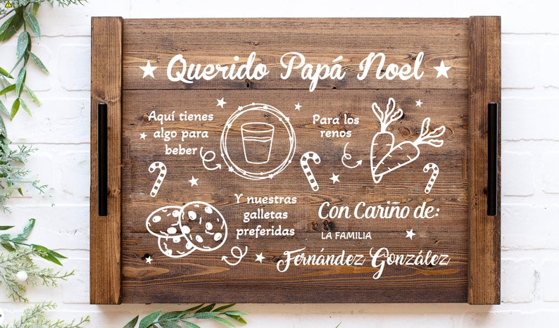 K&ouml;nnte beinhalten: Ein Holztablett mit einer wei&szlig;en Aufschrift, die "Querido Pap&aacute; Noel" lautet und eine Liste von Gegenst&auml;nden f&uuml;r den Weihnachtsmann enth&auml;lt, darunter Kekse, Milch und Karotten f&uuml;r die Rentiere. Die Aufschrift enth&auml;lt auch den Satz "Con Cari&ntilde;o de: La Familia Fern&aacute;ndez Gonz&aacute;lez".