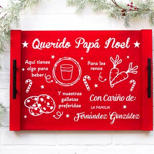K&ouml;nnte beinhalten: Rotes Holztablett mit wei&szlig;er Aufschrift "Querido Pap&aacute; Noel" und einer Liste mit Artikeln f&uuml;r den Weihnachtsmann und die Rentiere. Die Liste enth&auml;lt ein Glas Milch, Kekse und Karotten. Das Tablett hat auch schwarze Griffe.