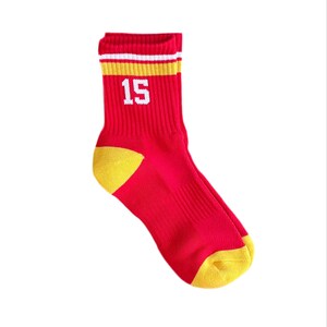 May include: Red and yellow athletic socks with a white stripe and the number 15 printed on the front.