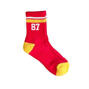 May include: Red and yellow striped athletic socks with the number 87 printed in white.