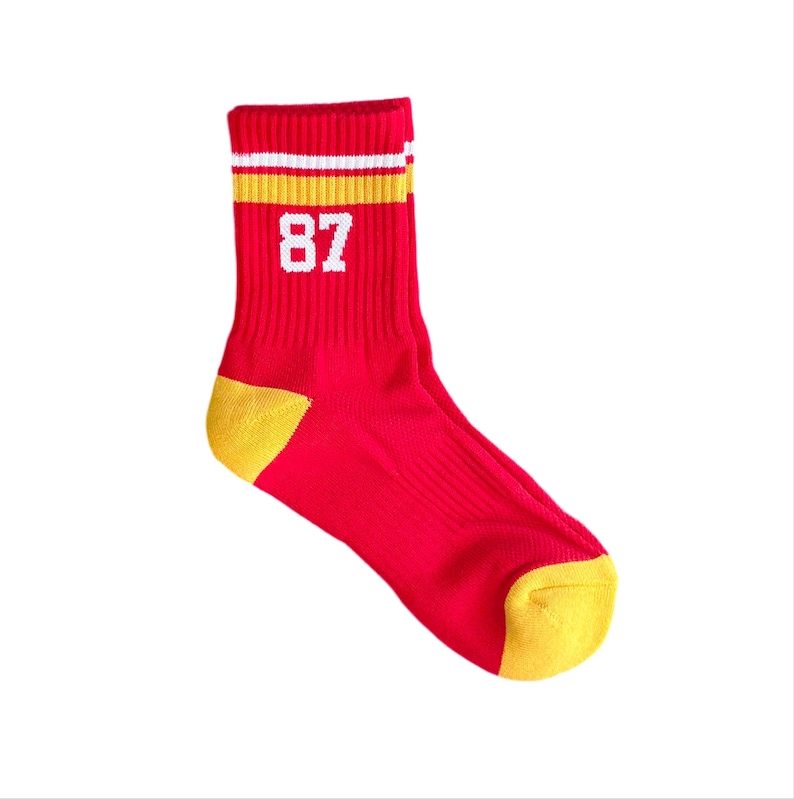May include: Red and yellow striped athletic socks with the number 87 printed in white.