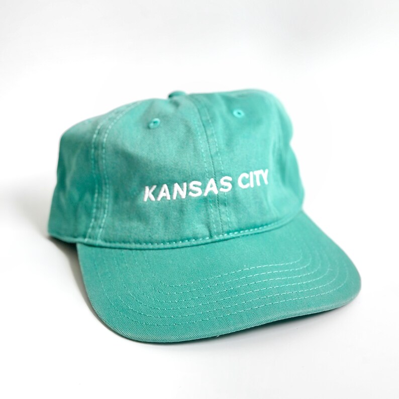 Puede incluir: Una gorra de b&eacute;isbol azul turquesa con texto bordado en blanco que dice "KANSAS CITY".