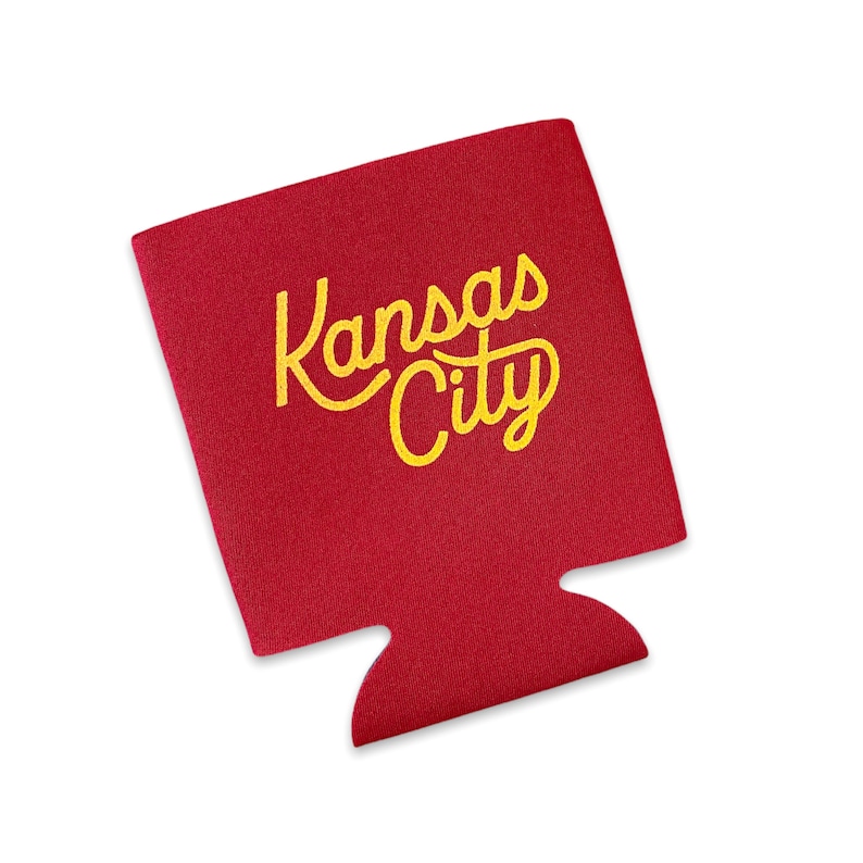 May include: Red foam can cooler with the text "Kansas City" in yellow lettering.